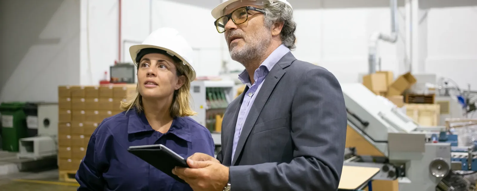Chef d’équipe qui explique les consignes à une opératrice, tablette en main