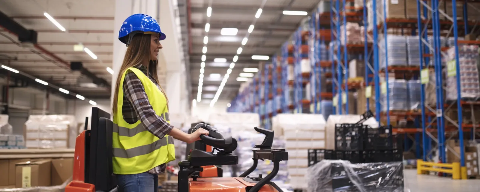 Conductrice de chariot élévateur dans un entrepôt logistique
